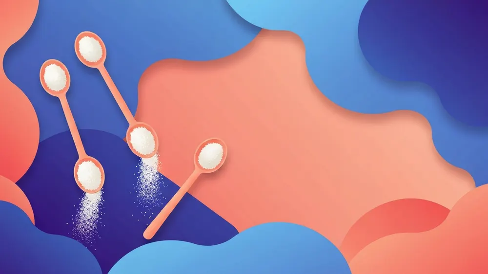Three level teaspoons of sugar next to one filled tablespoon on a kitchen counter